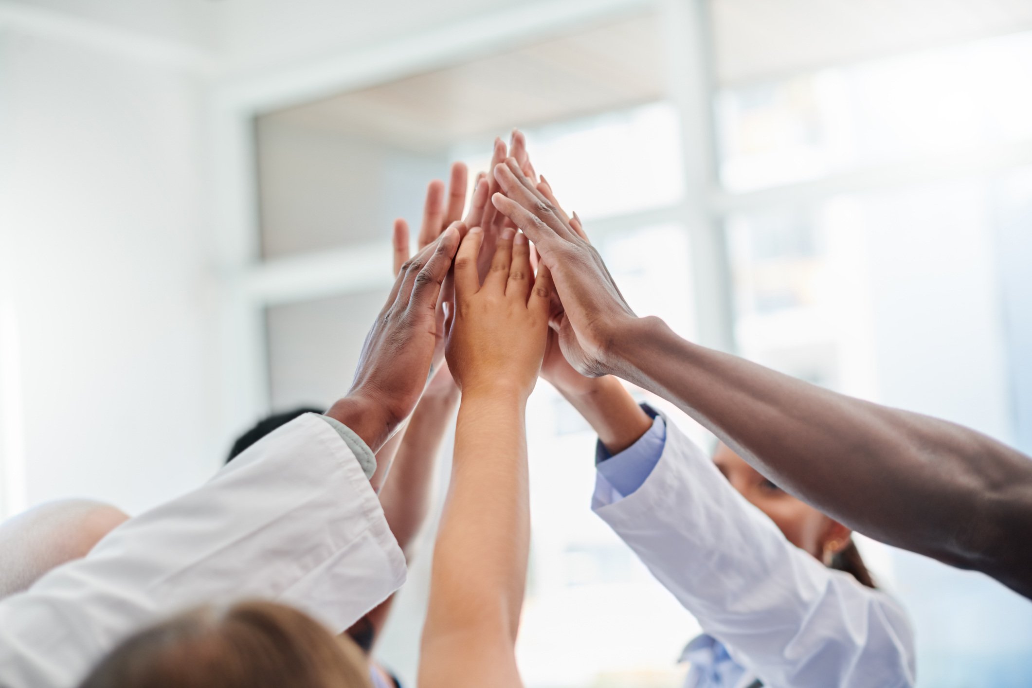 Healthcare workers hold up hands in a high-five