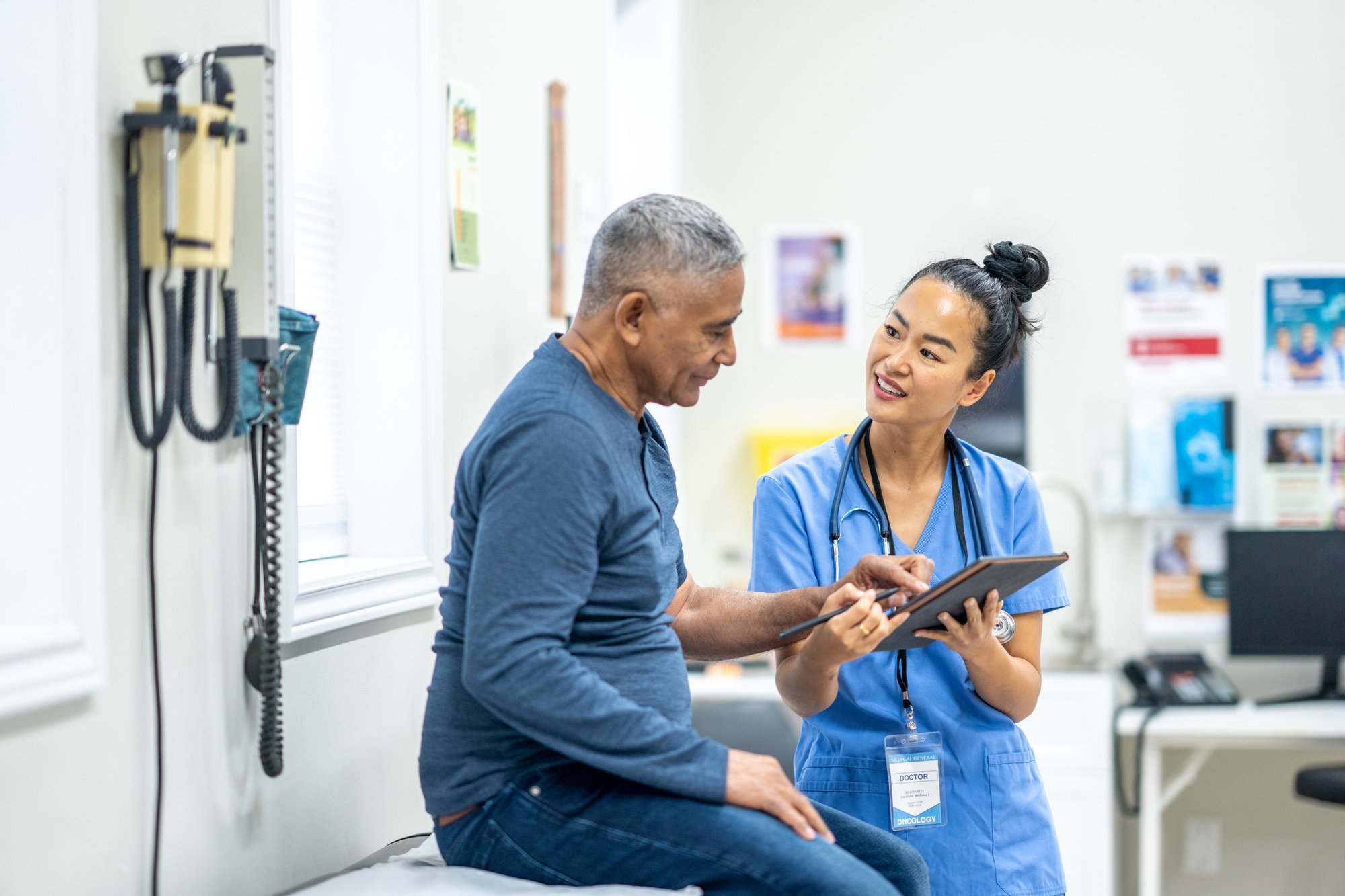 A health care worker looks at a clipboard with an elderly patient