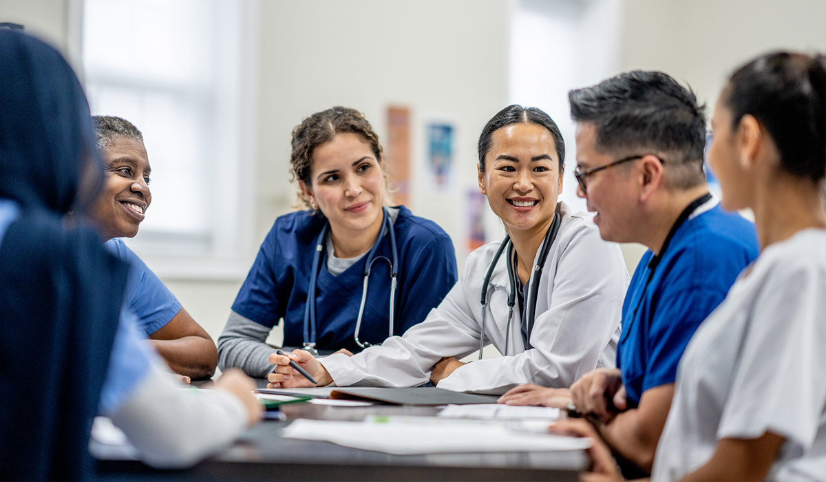 Healthcare workers gather around a conference table