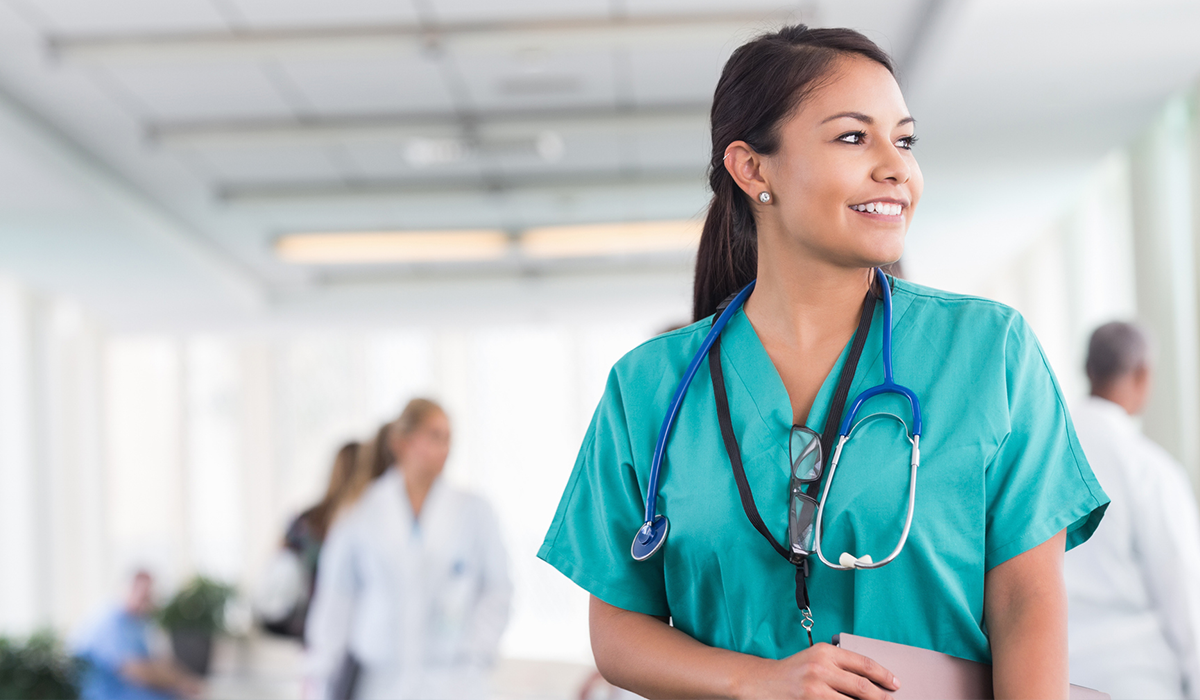 A healthcare worker smiles gazing out a window