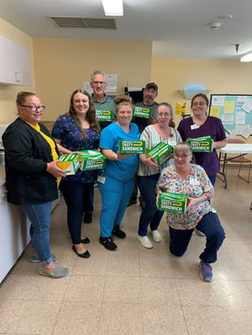 Eight staff members at Valley View pose holding boxes from Subway Sandwiches.