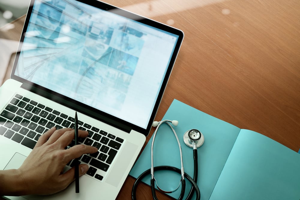 top view of Medicine doctor hand working with modern computer and smart phone on wooden desk as medical concept-3